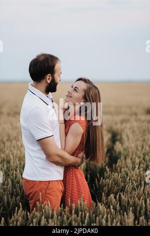 Felice coppia di mezza età che abbraccia il campo di grano, donna allegra caucasica e uomo innamorato in piedi insieme all'aperto Foto Stock