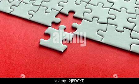 Puzzle su sfondo rosso con spazio personalizzabile per testo o idee. Spazio di copia. Foto Stock