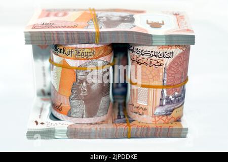 Egitto rotoli di denaro e pile di nuove prima egiziana 10 LE EGP dieci libbre polimero di plastica banconota isolato su sfondo bianco, egiziano sterline cash mo Foto Stock