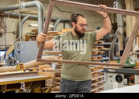 Kalamazoo, Michigan - operai specializzati costruiscono armadi personalizzati presso il negozio Homestead Cabinetmakers, situato nel Park Trades Center. Foto Stock