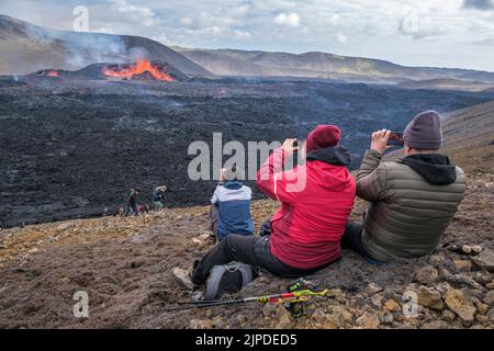 Turisti che fotografano l'eruzione del vulcano Meradalir, Penisola di Reykjanes, Islanda, agosto 2022 Foto Stock