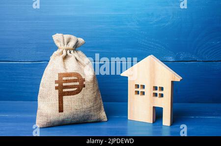 Casa con silhouette di Figurine e sacchetto di pesos filippino. Comprando e vendendo il bene immobile. Manutenzione, miglioramento della proprietà. Mutuo ipotecario. Vendita di hou Foto Stock