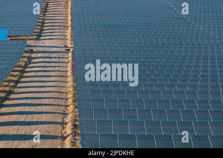 Centrale solare con pannelli fotovoltaici in collina. Foto di sfondo per le energie rinnovabili. Concetto di energia sostenibile. Pannelli fotovoltaici di impianto solare. Foto Stock