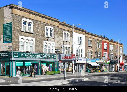 Street scene di Seven Kings High Road shopping parade con appartamenti residenziali a due piani case appartamento sopra i negozi a Redbridge East London Inghilterra Regno Unito Foto Stock