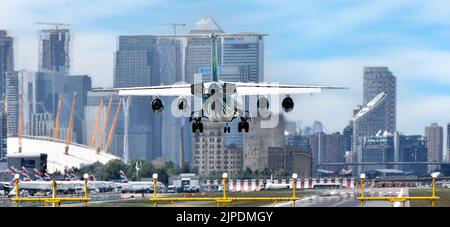 Primo piano vista posteriore di un aereo passeggeri a quattro motori che atterra all'aeroporto di London City Newham con O2 & Arena Canary Wharf a London Docklands Inghilterra UK Foto Stock