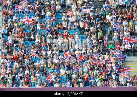 Adulti bambini e famiglie a Londra 2012 Giochi Paralimpici spettatori seduti in stand temporanei per guardare l'evento di calcio caldo giorno estivo Inghilterra UK Foto Stock