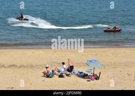 Guardando giù dalle dune di sabbia di Winterton-on-Sea si gode un viaggio ad alta velocità su Jet Ski con le persone che guardano le vacanze sulla spiaggia sabbiosa vacanza Inghilterra Regno Unito Foto Stock