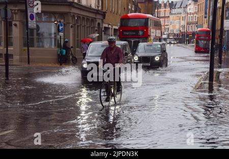 Londra, Regno Unito. 17th agosto 2022. Un ciclista attraversa una King's Cross Road allagata mentre piogge torrenziali e inondazioni improvvise colpiscono la capitale dopo mesi di siccità. Credit: Vuk Valcic/Alamy Live News Foto Stock