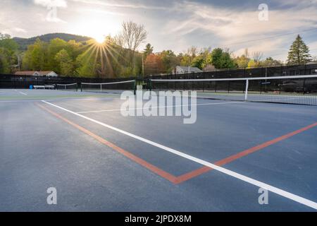 Nuovi campi da tennis blu all'aperto con linee bianche e linee rosse di pickleball e stella del sole sullo sfondo. Foto Stock