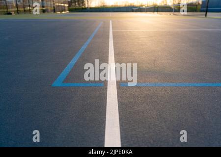 Foto ravvicinata del nuovo campo da tennis blu all'aperto con linee di pickleball blu chiaro. Foto Stock
