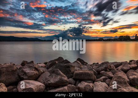 Pietre sulla riva del lago Tramonto Lago di Costanza con le nuvole nel cielo Foto Stock