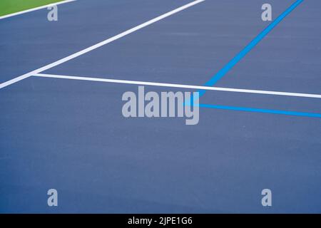 Foto ravvicinata del nuovo campo da tennis blu all'aperto con linee di pickleball blu chiaro. Foto Stock