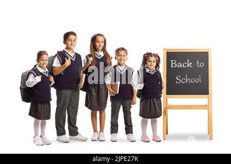 Gli scolari sono accanto a una piccola lavagna con un messaggio di ritorno a scuola isolato su sfondo bianco Foto Stock