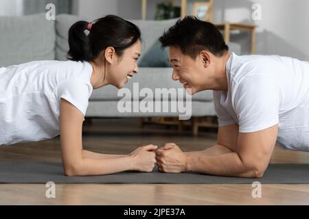 Vista laterale dello sportivo uomo asiatico e della donna che si uniscono Foto Stock