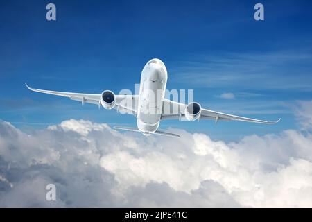 L'aeroplano commerciale vola dalle nubi bianche dense e guadagna l'altitudine Foto Stock