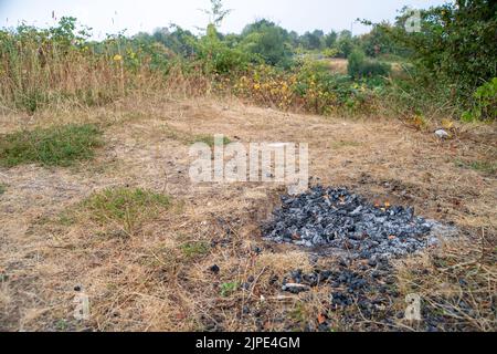 Slough, Berkshire, Regno Unito. 17th agosto, 2022. I resti di un altro barbecue vicino al fiume Jubilee a Slough. I vigili del fuoco hanno messo in guardia le persone in merito agli incendi, poiché la campagna rimane più asciutta dopo le settimane senza pioggia e senza due onde di calore. Credit: Maureen McLean/Alamy Live News Foto Stock