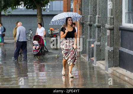 Londra, Regno Unito. 16th ago, 2022. Una donna si protegge dalla pioggia sotto un ombrello durante il tempo umido a Londra. Il MET Office ha emesso un avvertimento meteorologico giallo per i temporali e i pesanti downpours nella maggior parte delle parti del paese per i prossimi giorni. (Credit Image: © Dinendra Haria/SOPA Images via ZUMA Press Wire) Foto Stock