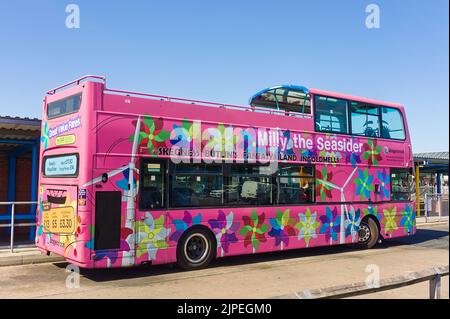 Un autobus a due piani scoperto rosa a due piani presso la stazione degli autobus in una giornata di sole a Skegness Foto Stock