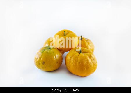 Superficie ricoperta da cinque tangerini freschi e succosi maturi, composizione isolata su fondo bianco. Foto Stock