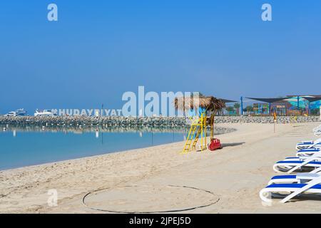 Completamente attrezzata per le attività di svago della famiglia spiaggia pubblica con enorme cartello hashtag sullo sfondo nel centro ricreativo di Abu Dhabi di Hudayriyat Island, Emirati Arabi Uniti Foto Stock