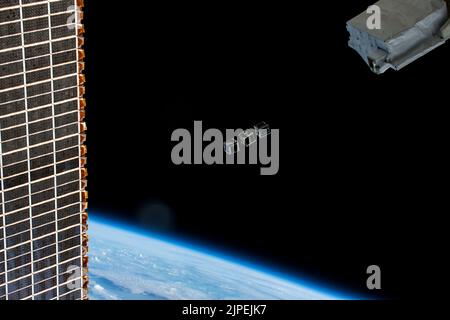 Atmosfera terrestre. 12th ago, 2022. Un trio di CubeSats (TUMnanoSAT, FUTABA, e HSU-SAT1) progettati per programmi di istruzione e ricerca sono raffigurati pochi istanti dopo la loro implementazione da un piccolo dispiegatore satellitare (in alto a destra) posizionato fuori dal modulo di laboratorio Kibo. La Stazione spaziale Internazionale stava orbitando 259 miglia sopra l'Oceano Atlantico al momento di questa fotografia. Una parte di uno degli array solari principali della stazione è anche raffigurata a sinistra. Credit: NASA/ZUMA Press Wire Service/ZUMAPRESS.com/Alamy Live News Foto Stock