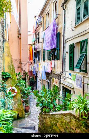 Vicolo stretto, case colorate con lavaggi appesi ad asciugare a Vernazza, cinque Terre, la Spezia, Italia Foto Stock