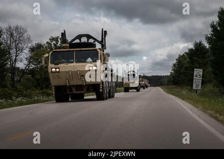 I soldati dell'esercito degli Stati Uniti della 851st Transportation Company partono per l'addestramento del convoglio durante l'esercitazione 2022 Combat Support Training (CSTX) a Fort McCoy, Wisconsin, 15 agosto 2022. CSTX 22-02 offre alle unità di formazione a rotazione l'opportunità di migliorare la competenza di formazione specifica per i MOS collettivi e di migliorare la prontezza, fornendo al contempo una varietà di ambienti di formazione integrati virtuali e live per replicare una minaccia di pari livello nelle operazioni di combattimento su larga scala all'interno di operazioni multidominio. Le unità di formazione operano in un ambiente austero, sviluppando e mettendo in pratica le competenze nelle operazioni notturne Foto Stock