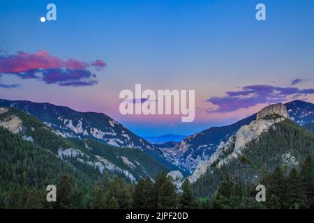 luna piena ambientazione in un cielo prima dell'alba sul canyon del torrente beaver vicino york, montana Foto Stock