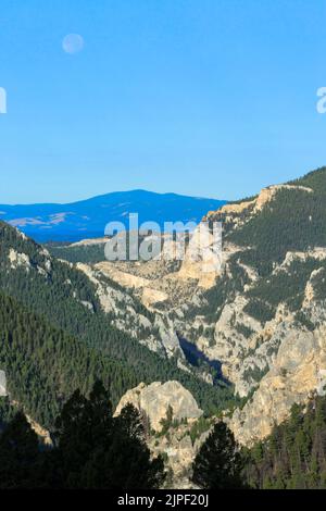 luna piena impostazione sul canyon del torrente castoro nella foresta nazionale di helena vicino a york, montana Foto Stock