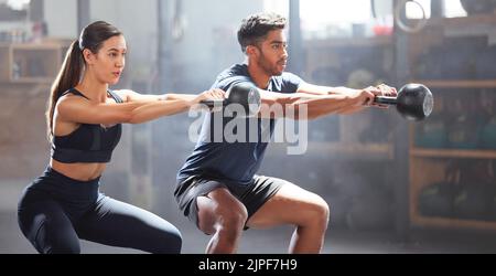 Slim, fitness e palestra coppia di esercizio con manubri attrezzature, facendo allenamento corpo inferiore o allenamento in una struttura benessere. Giovane donna e uomo Foto Stock