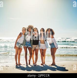 Basta dire la parola spiaggia e ci si può trovare. Un gruppo di amiche che trascorrono la giornata in spiaggia. Foto Stock