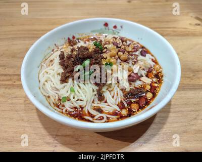 Spaghetti di Sichuan con salsa piccante nel recipiente bianco per mangiare Foto Stock