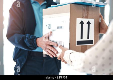 Consegna puntuale presso la tua residenza. Un addetto alla consegna irriconoscibile che consegna il pacco a una cliente femminile. Foto Stock