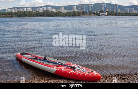 SUP bordo sulla riva del fiume. Paddle board sulla riva del lago. Foto Stock