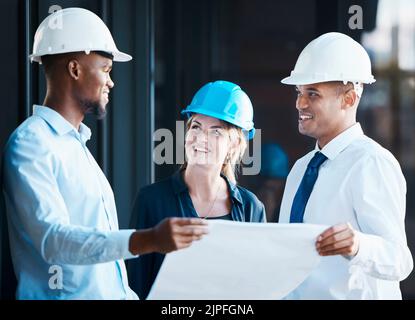 Architetto, ingegnere e appaltatore di edifici che guardano piani o progetti mentre si parla e si discute di strategia. Team o gruppo di costruttori che cercano Foto Stock