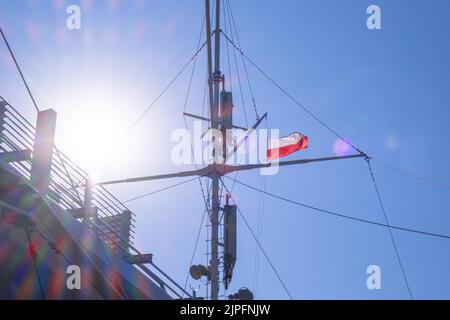 Bandiera della Polonia che sventola sul palo di bandiera della nave. Bandiera polacca che sbatte mentre navighi in barca sul mare. Giorno di sole Foto Stock