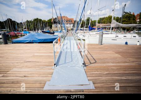 Berlino, Germania. 17th ago, 2022. L'accesso alla piattaforma galleggiante senza barriere dell'associazione 'Sablerhaus am Wannsee', che permette ai marinai di entrare più facilmente in barca. Dopo le Olimpiadi speciali del mondo 2023 a Berlino, la piattaforma, che costa 200.000 euro, deve essere smantellata di nuovo per altrettanto denaro perché, secondo l'autorità distrettuale, getta ombre sull'acqua e danneggia i pesci. Credit: Christoph Soeder/dpa/Alamy Live News Foto Stock