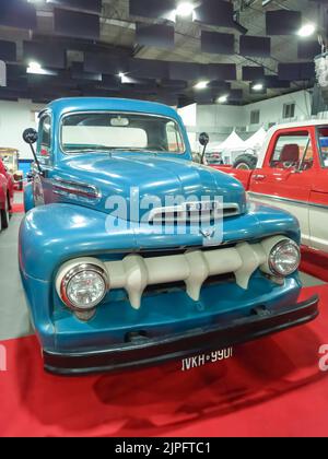 Vecchio camioncino blu Ford F 1 V8 1951 su tappeto rosso. Vista frontale. Griglia. Sala espositiva. Spettacolo di auto classica. Foto Stock