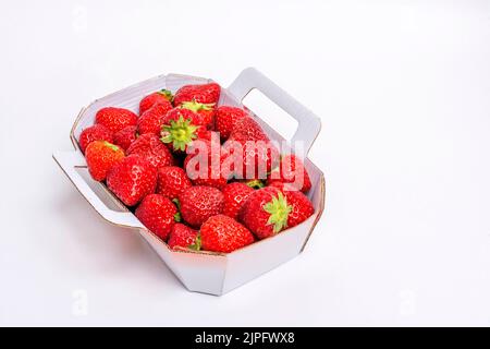 Fragole fresche disposte in un contenitore da asporto bianco su sfondo chiaro Foto Stock