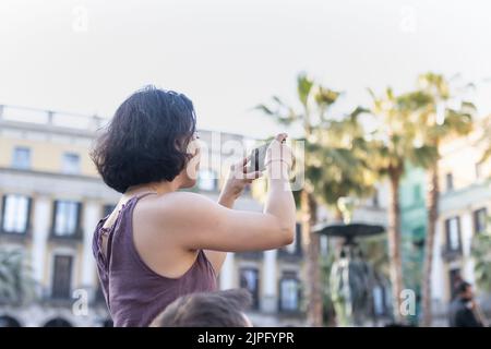 Barcellona, Spagna - 14 maggio 2022: Ragazza che scattano una foto con il suo cellulare al Plaza Real di Barcellona (Spagna). Foto Stock