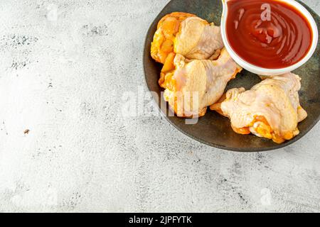 chicken drumstick and sauce, high angle top view Foto Stock