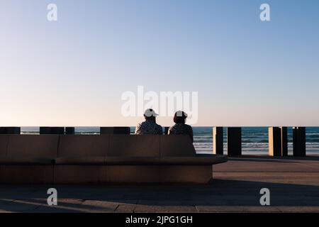 Una coppia seduta al molo Foto Stock