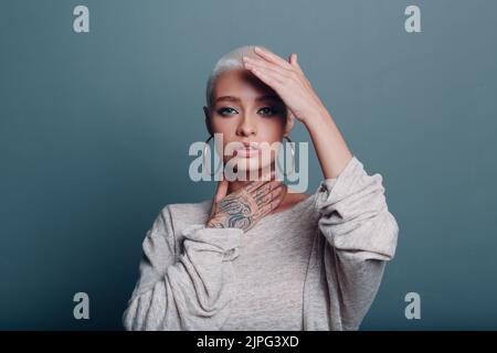 Giovane donna millenaria con corto ritratto dei capelli biondi facendo viso yoga auto massaggio viso per la pelle del viso Foto Stock
