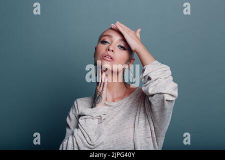 Giovane donna millenaria con corto ritratto dei capelli biondi facendo viso yoga auto massaggio viso per la pelle del viso Foto Stock