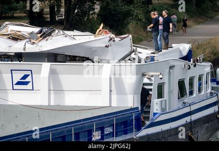 Dorsten, Germania. 18th ago, 2022. Gli investigatori della polizia dell'acqua sono in piedi su una nave il cui autista è ammaccato, sul canale Wesel-Datteln. Il convoglio spinto si era schiantato in un ponte stradale Dorsten. Lo skipper di 42 anni è stato ferito e ricoverato in ospedale. Sia la cabina della nave che il ponte sono stati danneggiati nell'incidente. Nel frattempo il ponte è stato chiuso al traffico stradale. Credit: Bernd Thissen/dpa/Alamy Live News Foto Stock