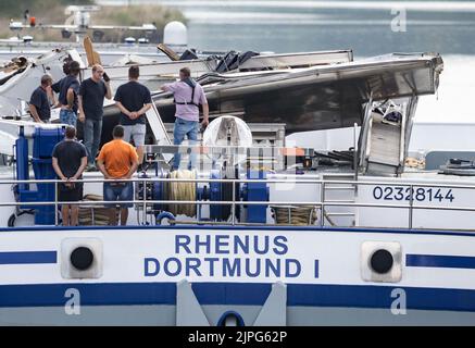 Dorsten, Germania. 18th ago, 2022. Gli investigatori della polizia idrica sono in piedi su una nave il cui taxi è stato ammaccato, sul canale Wesel-Datteln. Il convoglio spinto si era schiantato in un ponte stradale Dorsten. Lo skipper di 42 anni è stato ferito e ricoverato in ospedale. Sia la cabina della nave che il ponte sono stati danneggiati nell'incidente. Nel frattempo il ponte è stato chiuso al traffico stradale. Credit: Bernd Thissen/dpa/Alamy Live News Foto Stock