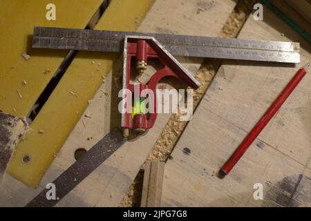 Linea e livello in officina. Strumento per le misurazioni. Dettagli di Falegnameria. Righello in acciaio. Foto Stock