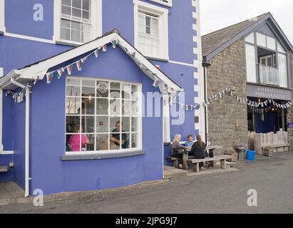 Persone che mangiano e bevono presso il porto di Aberaeron, Ceredigion, Galles, Regno Unito Foto Stock