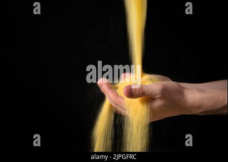 Astratto Farmer Sprinkles farina di mais polvere di polvere attraverso le mani Foto Stock