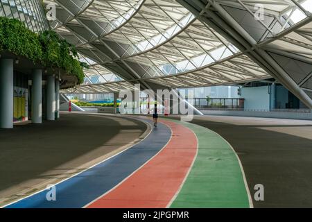 Un pareggiatore scherza sulla pista da corsa completamente riparata più grande fuori dallo Stadio Nazionale, Singapore. Foto Stock